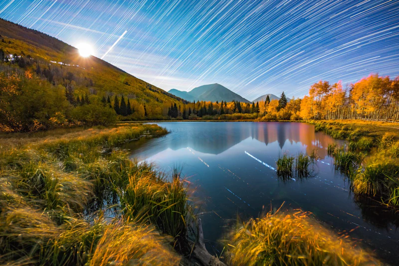 Long exposure star trails over an alpine lake.