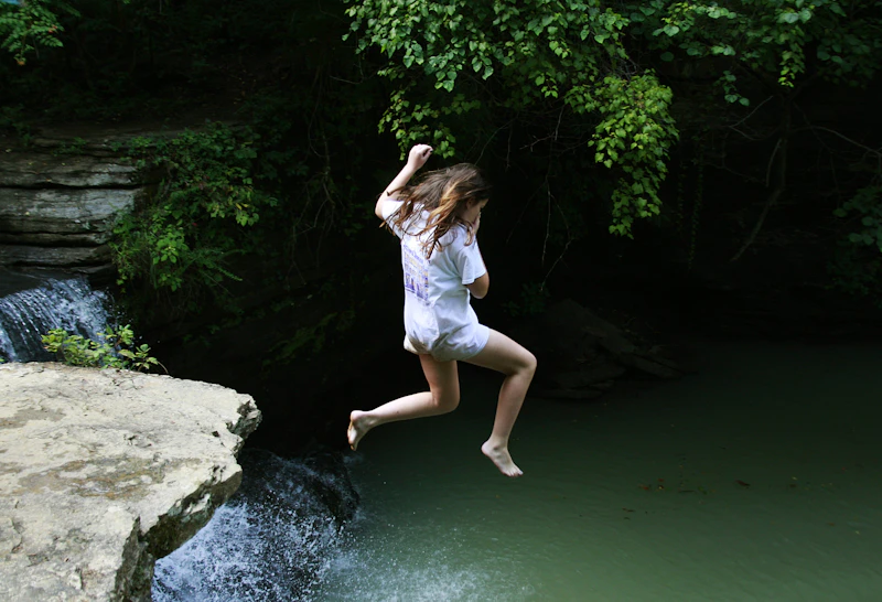Swimmer jumping into a natural pool.