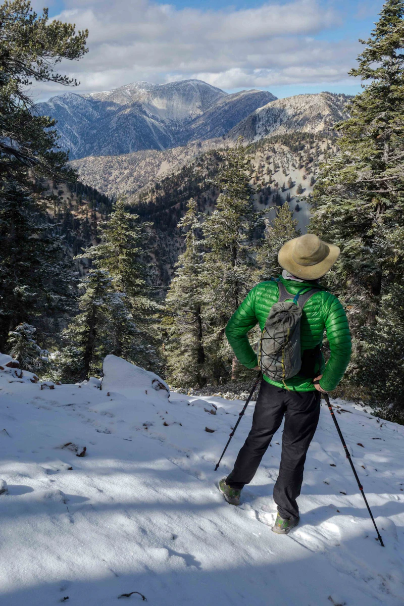a man standing in the snow overlooking mountains