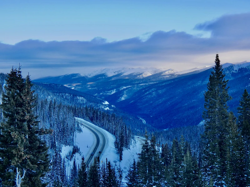 sunset view of a highway in winter through the mountains