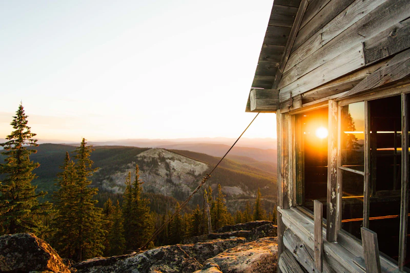 sunset through an old lookout tower cabin high in the mountains
