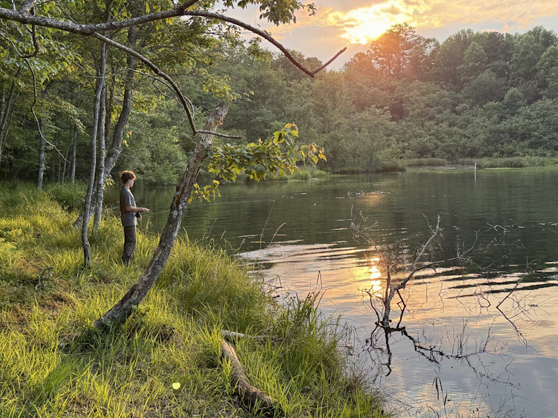 Boy fishing at sunset.