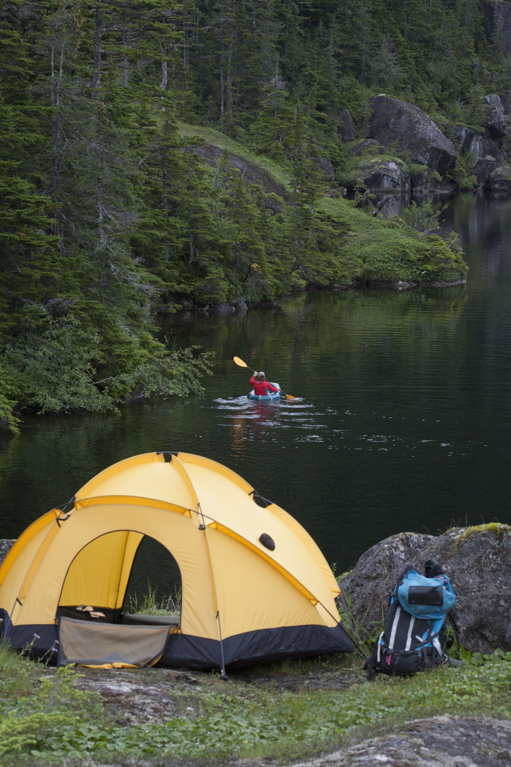 Kayaker paddles away from their campsite.