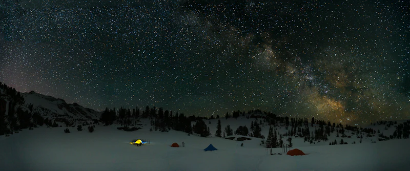Tent camping in the snow on a starry night.