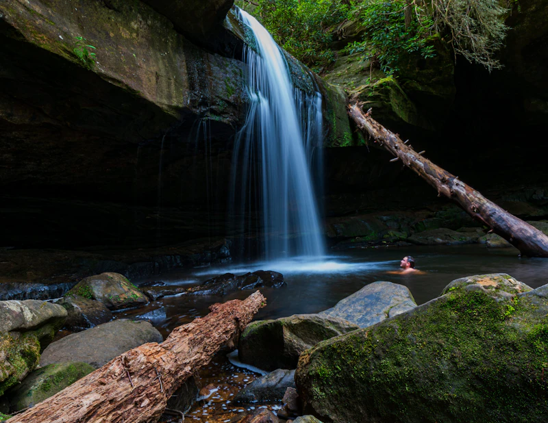 Swimmer under a waterfall.