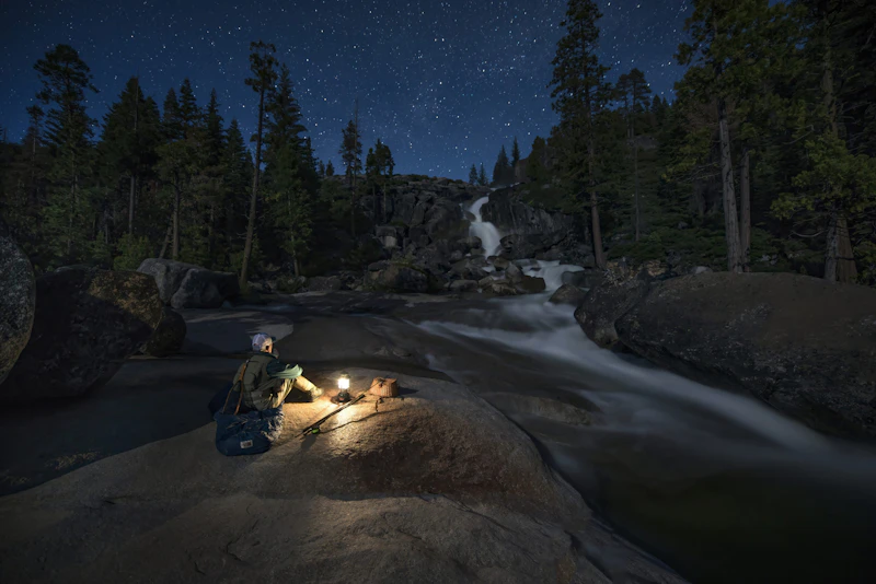 Fisherman camps by a waterfall.