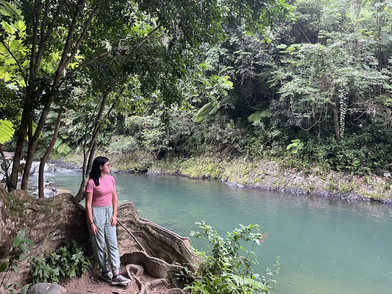 Woman stands by a river.