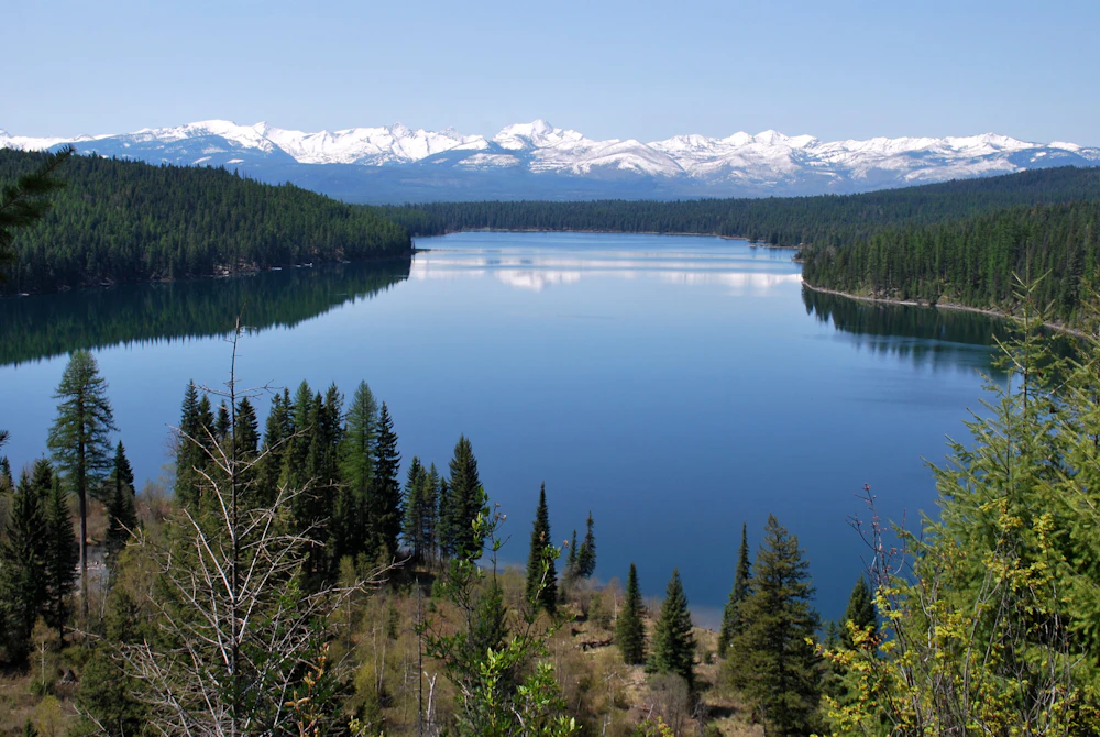 a large lake in front of snow covered mountains