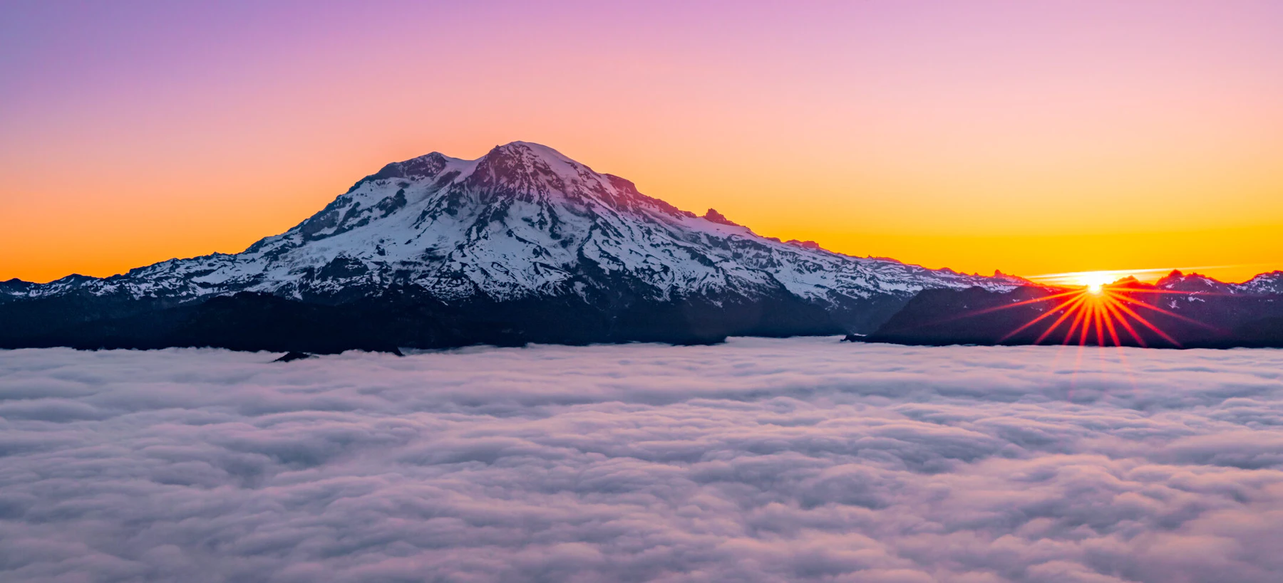 Mountain peak rises above the clouds.