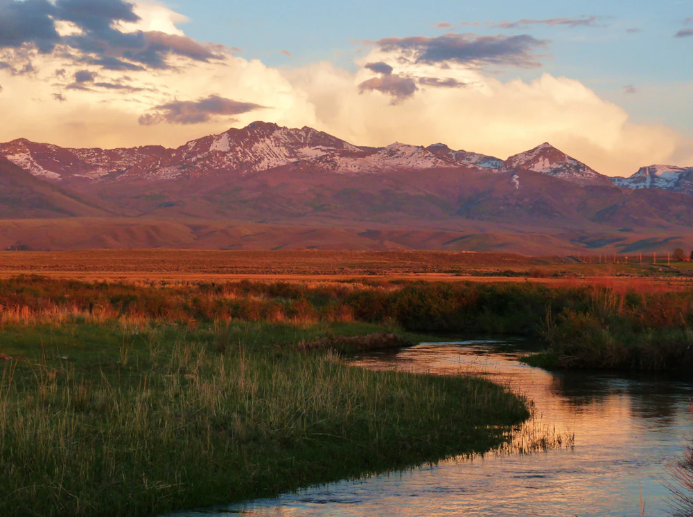 small creek and mountains in golden hour of sunset