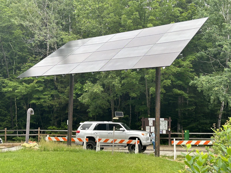 a large solar panel above a car in the forest