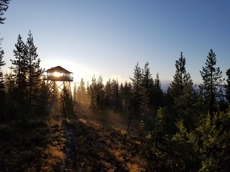 Sun rising over a fire lookout tower.