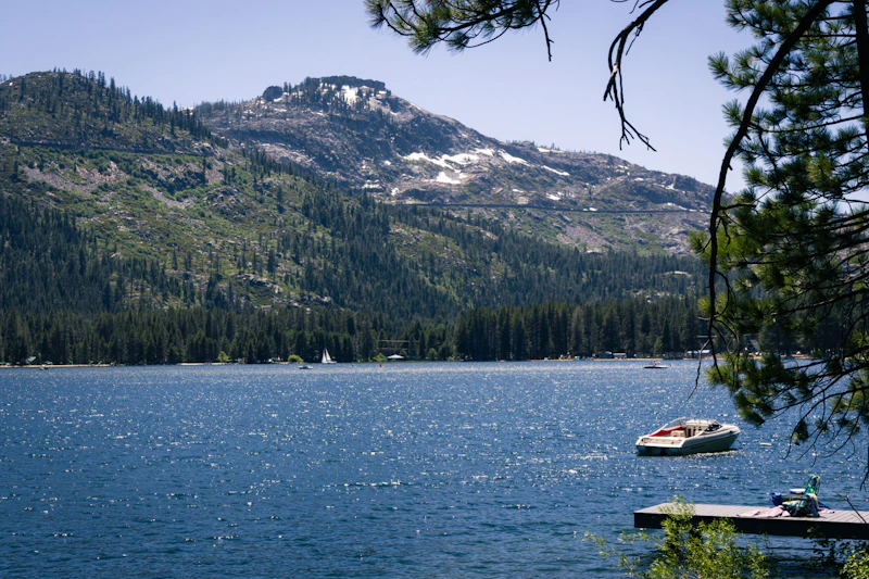 Powerboat floats in a lake surrounded by mountains..