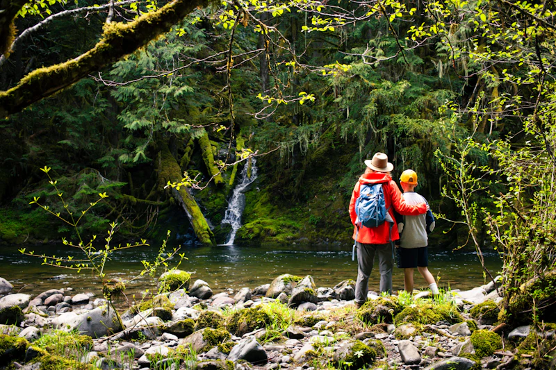 Mother and son look at a waterfall.