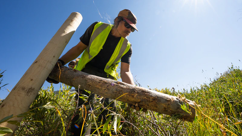 Crew member placing a post to build a Beaver Dam Analog.