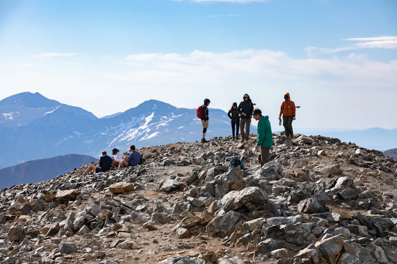 a group of hikers atop an alpine peak
