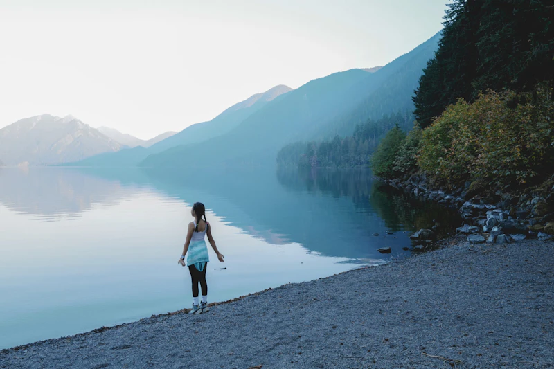 Girl takes a deep breath at the lake shore.