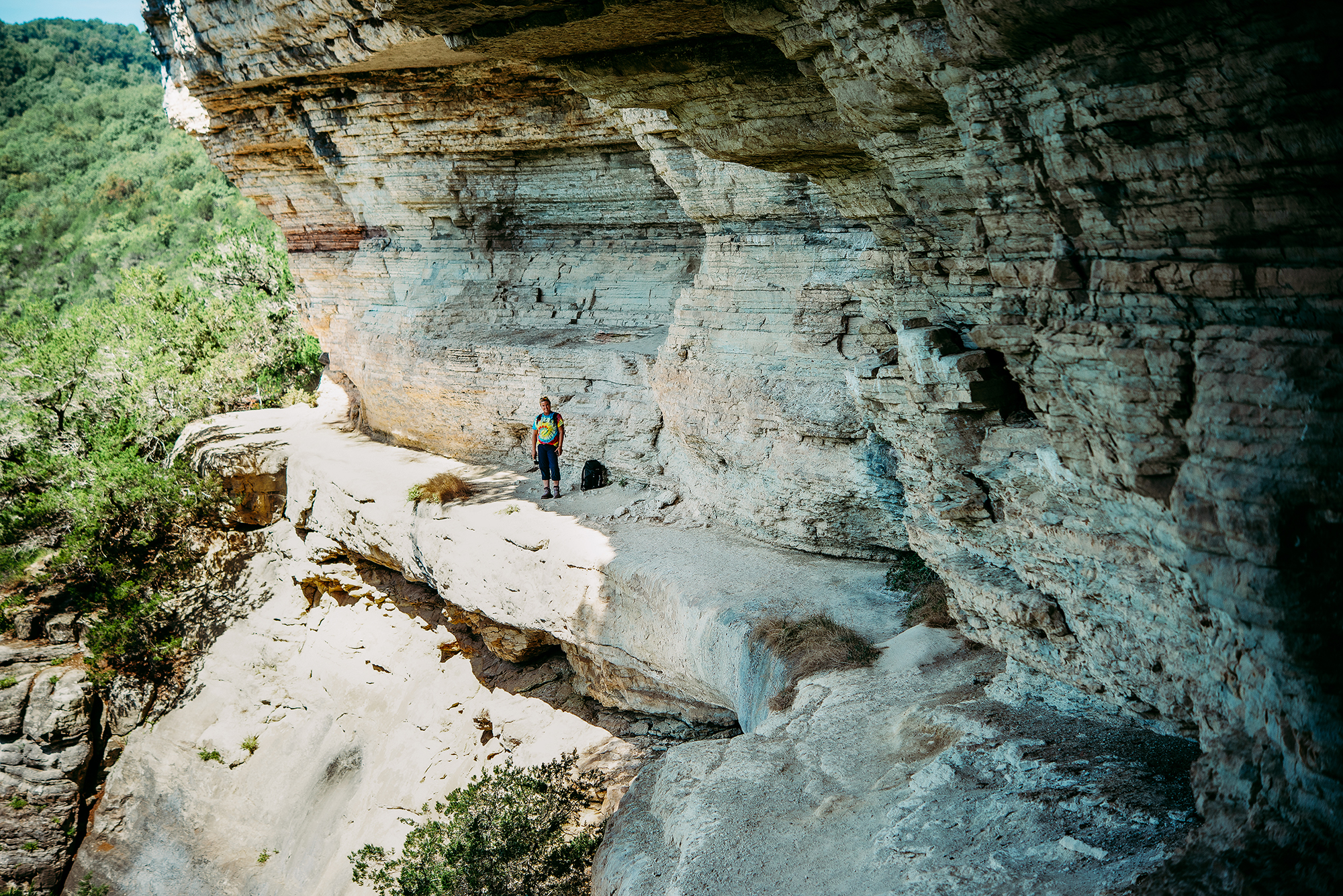 Hiker walks along a limestone bluff.