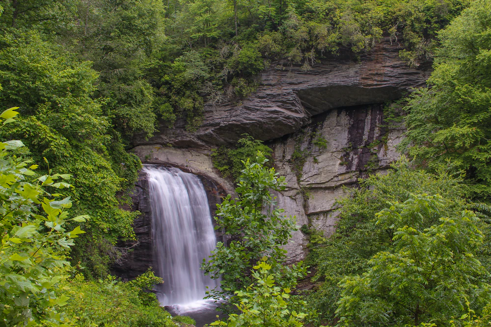 a large waterfall cascades down in a forest