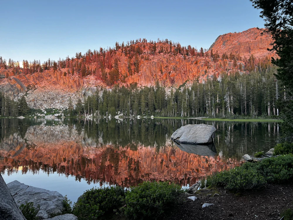 an alpine lake at sunset in pink light