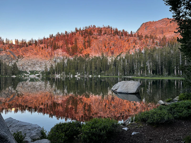 an alpine lake at sunset in pink light