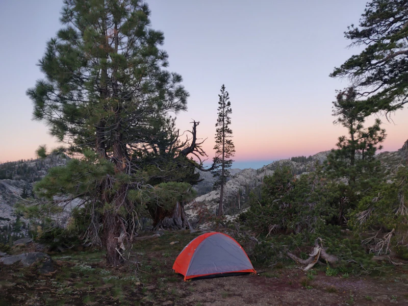 a small tent in the backcountry at sunset