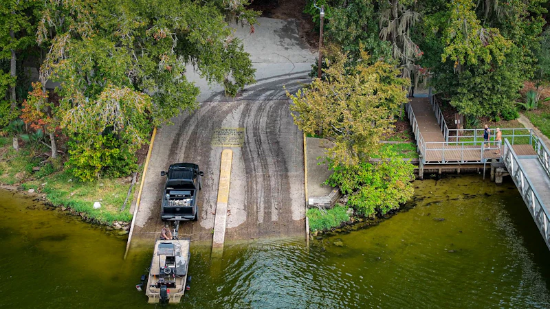 Truck backs into a boat launch.
