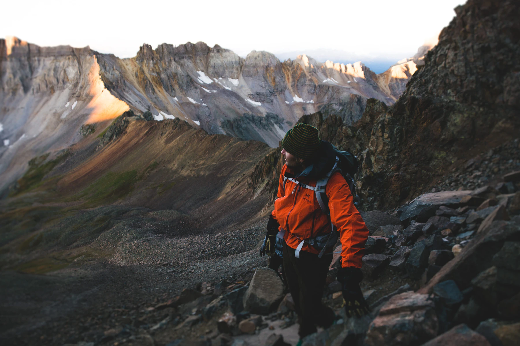 Hiker watches the sunrise over his shoulder.