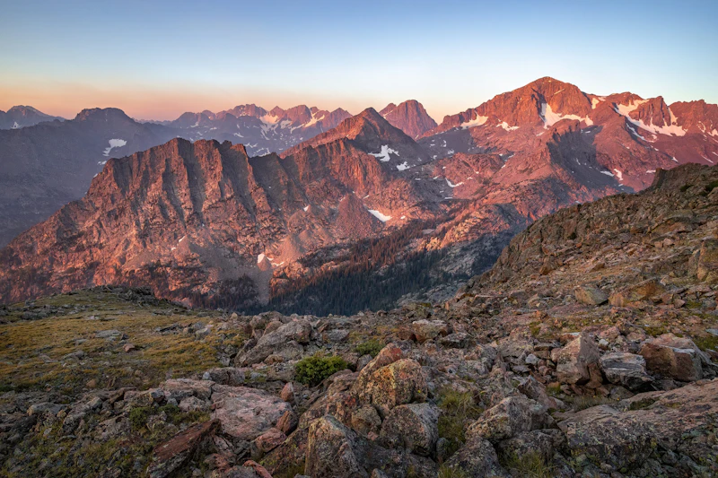 a majestic mountain range in pink light at sunset