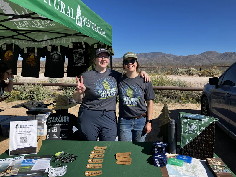 Two NFF staff members behind a table at an event.