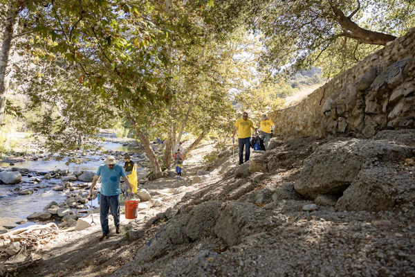 Volunteers pick up trash in a creek on the Angeles National Forest.