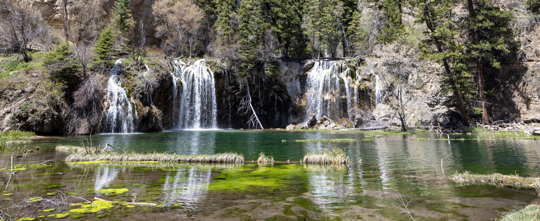Twin waterfalls pour into a gem-green lake.