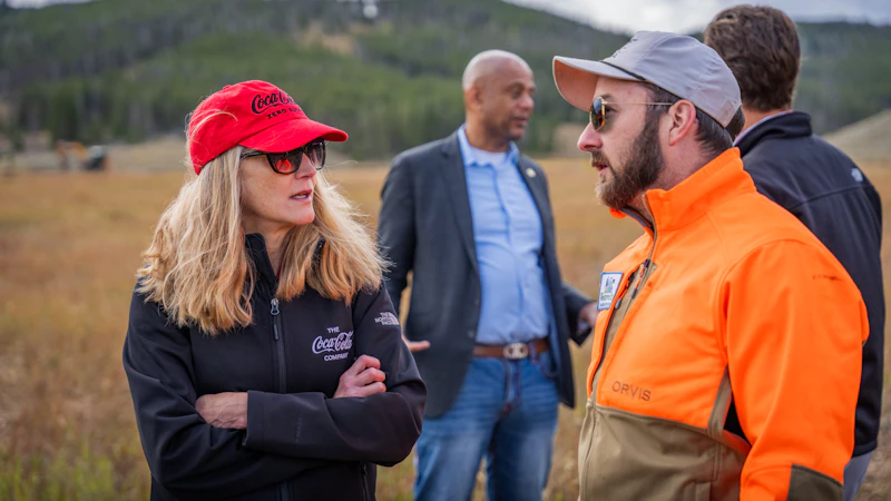 Team members from NFF partners Coca-Cola and Orvis talk at a project site.