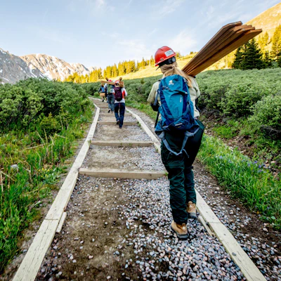 Trail crew volunteers carry lumber up an alpine trail near Grays and Torreys Peaks during a National Forest Foundation volunteer weekend, working to improve and sustain high-country recreation.